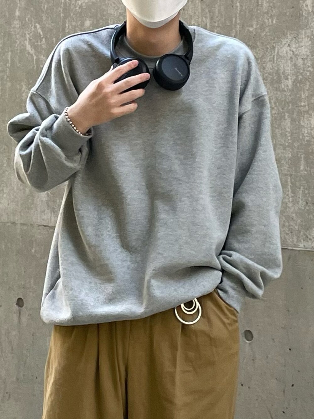 ベージュ系のパンツ、グレー系のスウェット、グレー系のスニーカーを着用したメンズの秋コーディネートの3枚目の写真