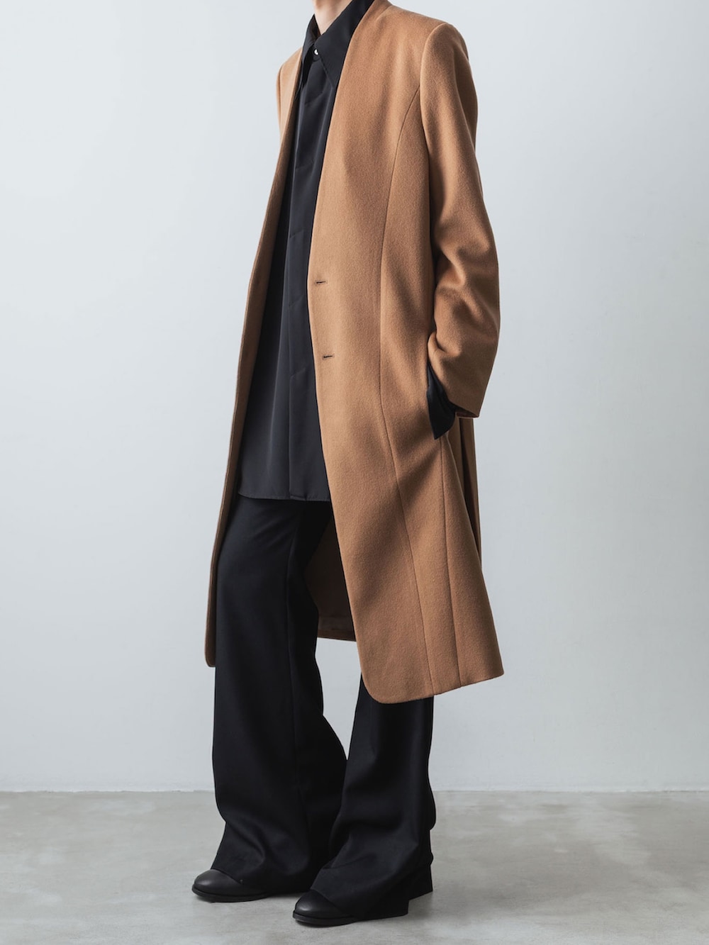 ベージュ系のチェスターコート、ブラック系のシャツ/ブラウス、ブラック系のスラックスを着用したメンズの冬コーディネートの2枚目の写真