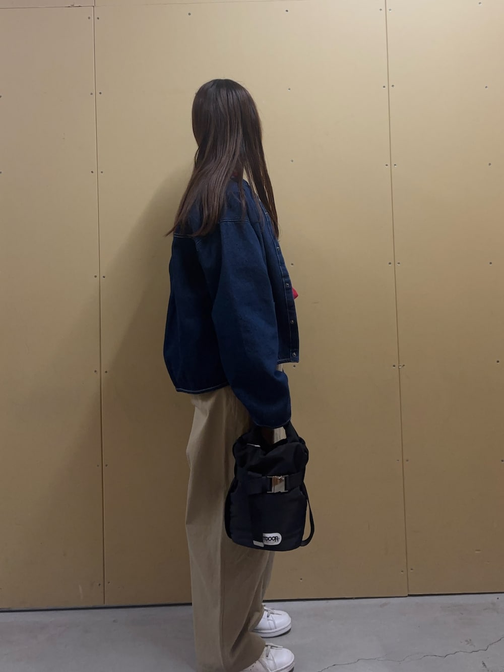 レッド系のニット/セーター、ブルー系のデニムジャケット、ベージュ系のチノパンツを着用したレディースの冬コーディネートの3枚目の写真