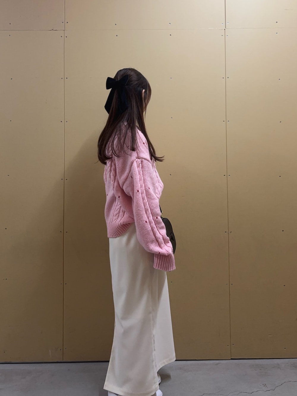 ピンク系のニット/セーター、ホワイト系のスカート、ブラック系のショルダーバッグを着用したレディースの秋コーディネートの3枚目の写真