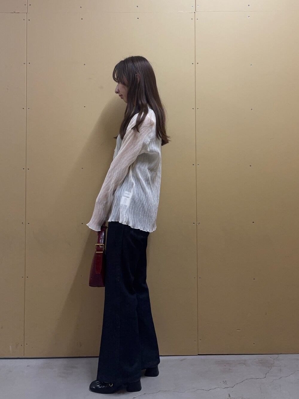 グレー系のタンクトップ、ホワイト系のシャツ/ブラウス、ブルー系のデニムパンツを着用したレディースの秋コーディネートの2枚目の写真