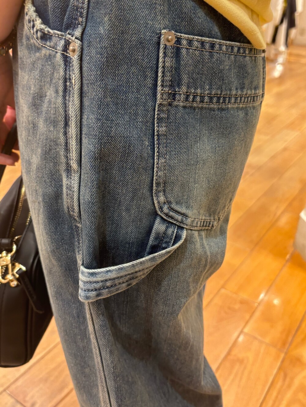 イエロー系のTシャツ/カットソー、ブルー系のデニムパンツ、ブラック系のショルダーバッグを着用したレディースの夏コーディネートの5枚目の写真