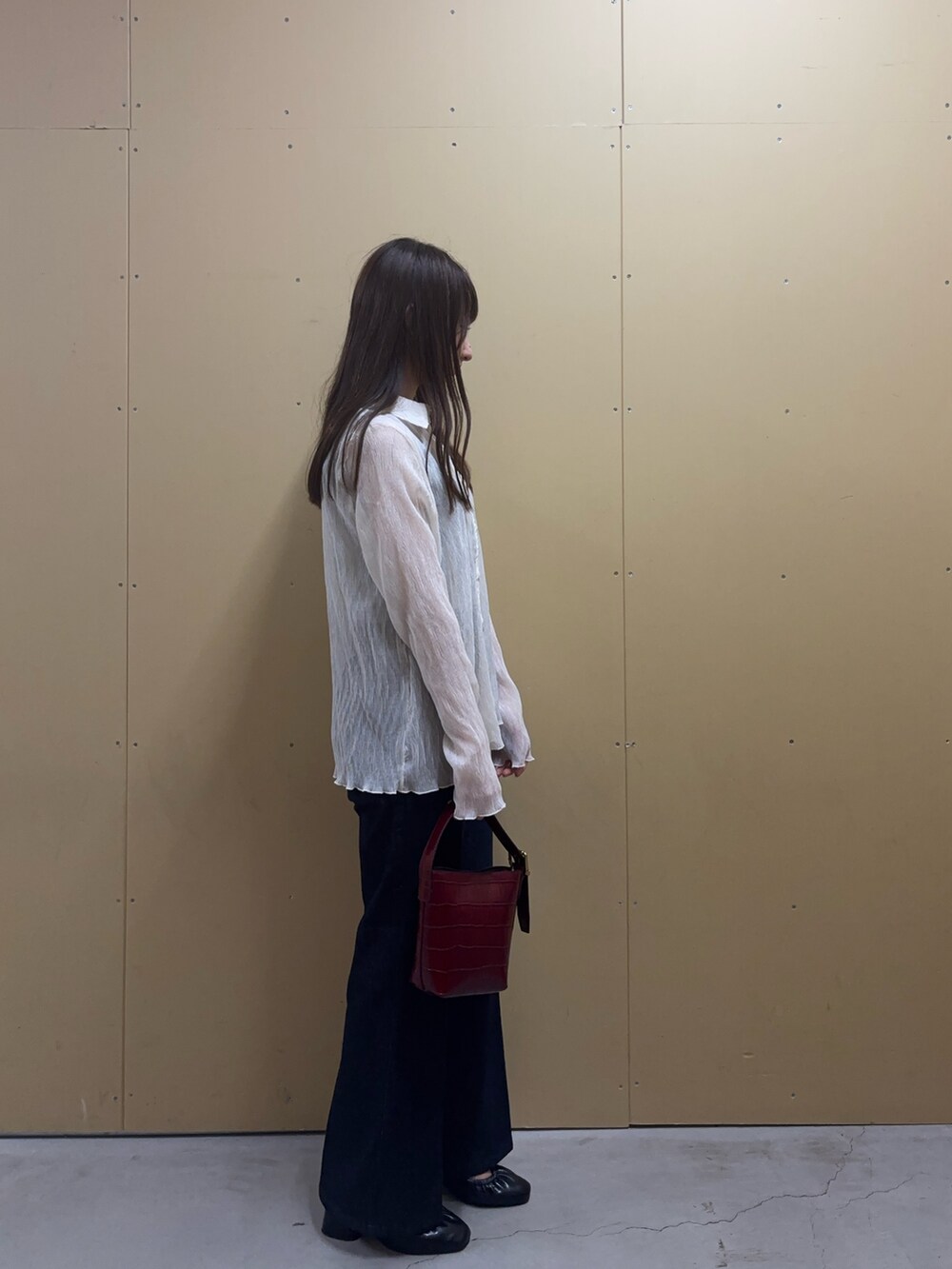 グレー系のタンクトップ、ホワイト系のシャツ/ブラウス、ブルー系のデニムパンツを着用したレディースの秋コーディネートの3枚目の写真