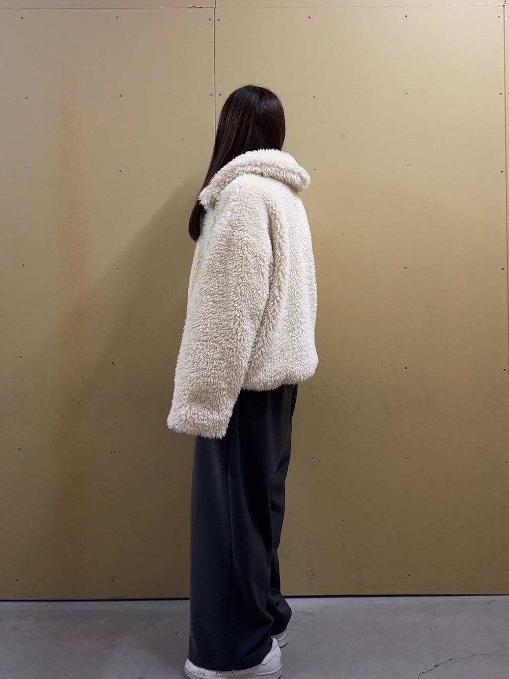 ホワイト系のムートンコートを着用したレディースの秋コーディネートの2枚目の写真