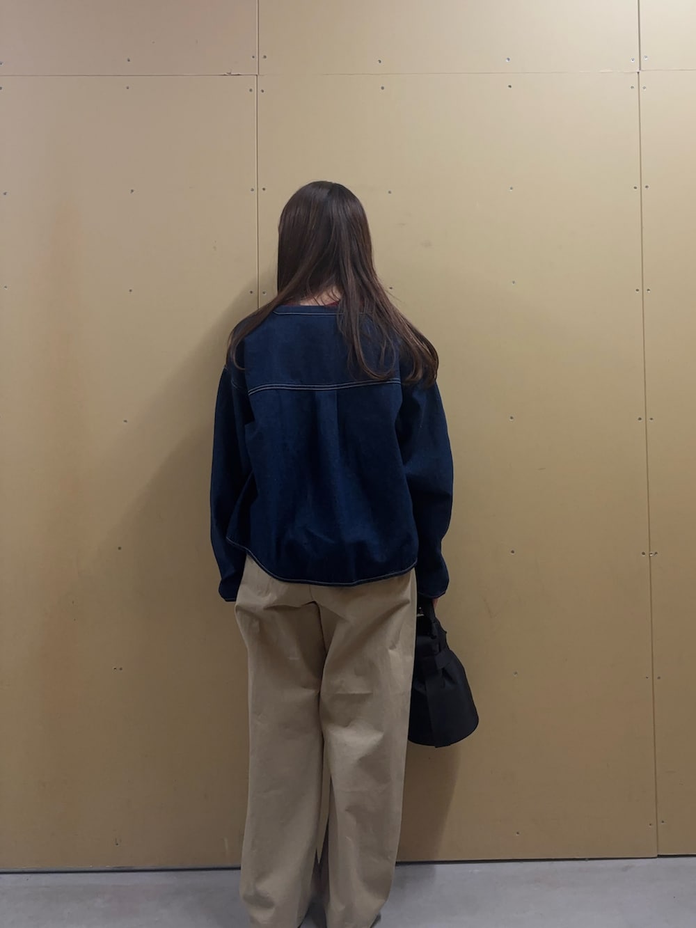 レッド系のニット/セーター、ブルー系のデニムジャケット、ベージュ系のチノパンツを着用したレディースの冬コーディネートの4枚目の写真