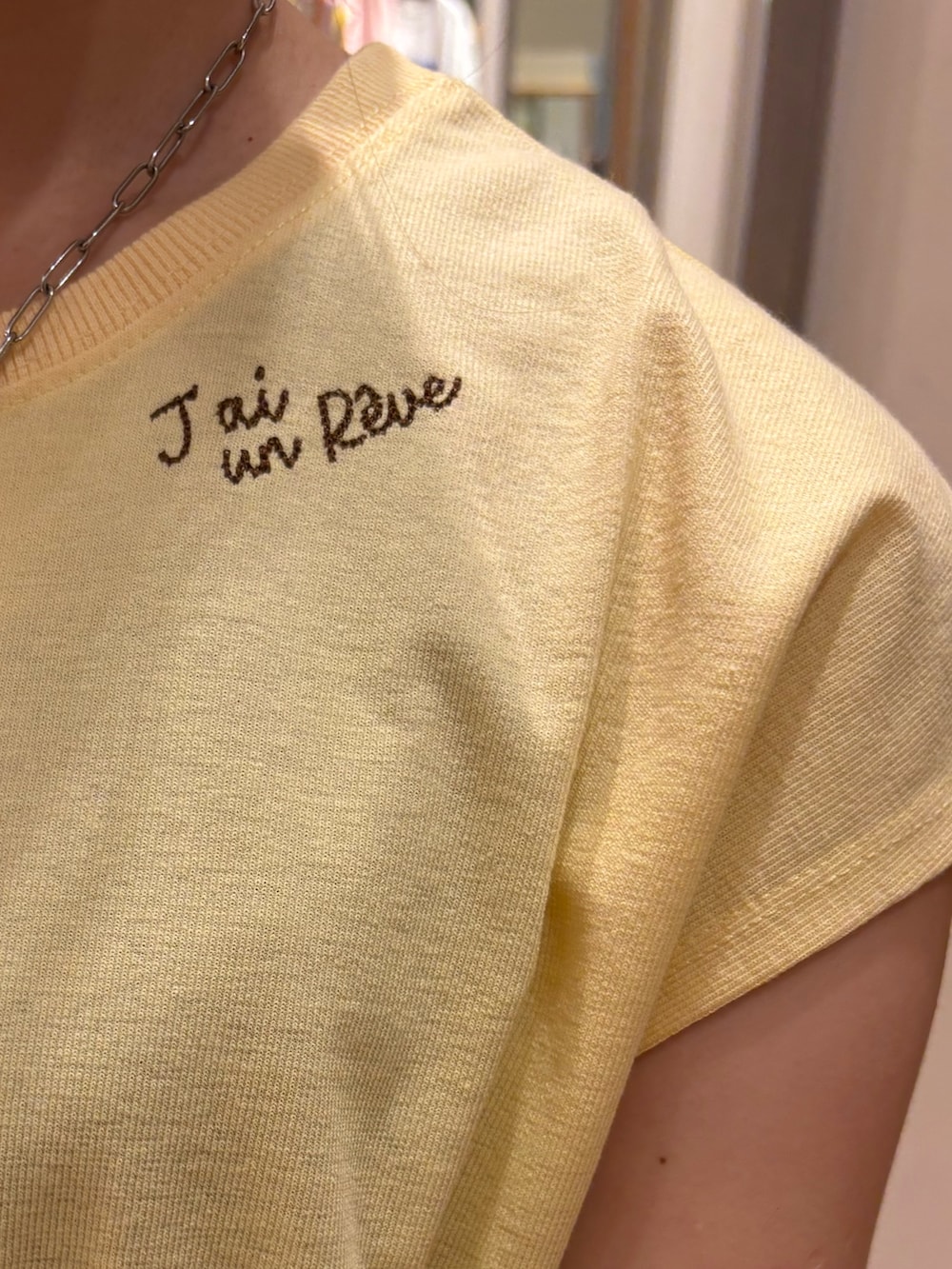 イエロー系のTシャツ/カットソー、ブルー系のデニムパンツ、ブラック系のショルダーバッグを着用したレディースの夏コーディネートの4枚目の写真