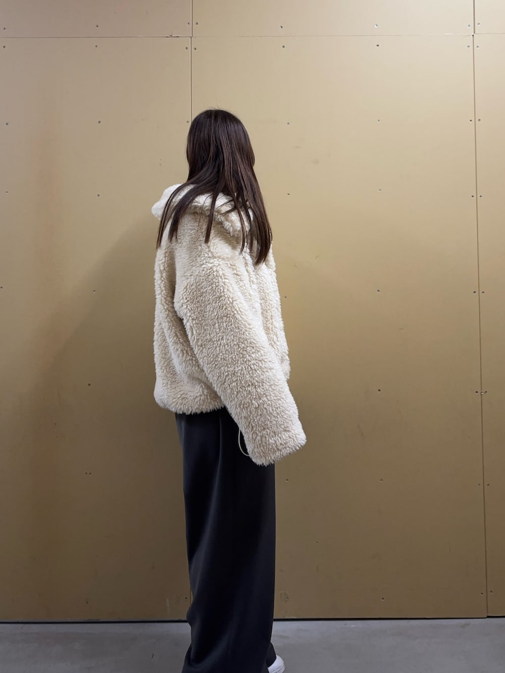 ホワイト系のムートンコートを着用したレディースの秋コーディネートの3枚目の写真