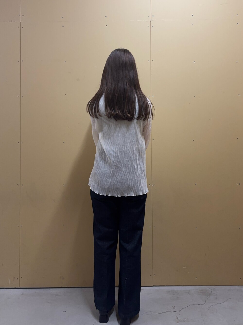 グレー系のタンクトップ、ホワイト系のシャツ/ブラウス、ブルー系のデニムパンツを着用したレディースの秋コーディネートの4枚目の写真