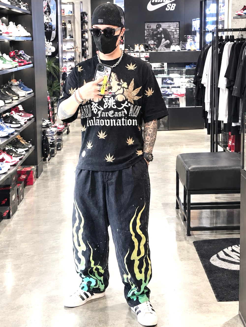 ホワイト系のスニーカー、ブラック系のデニムジャケット、ブラック系のTシャツ/カットソーを着用したメンズの秋コーディネートの2枚目の写真