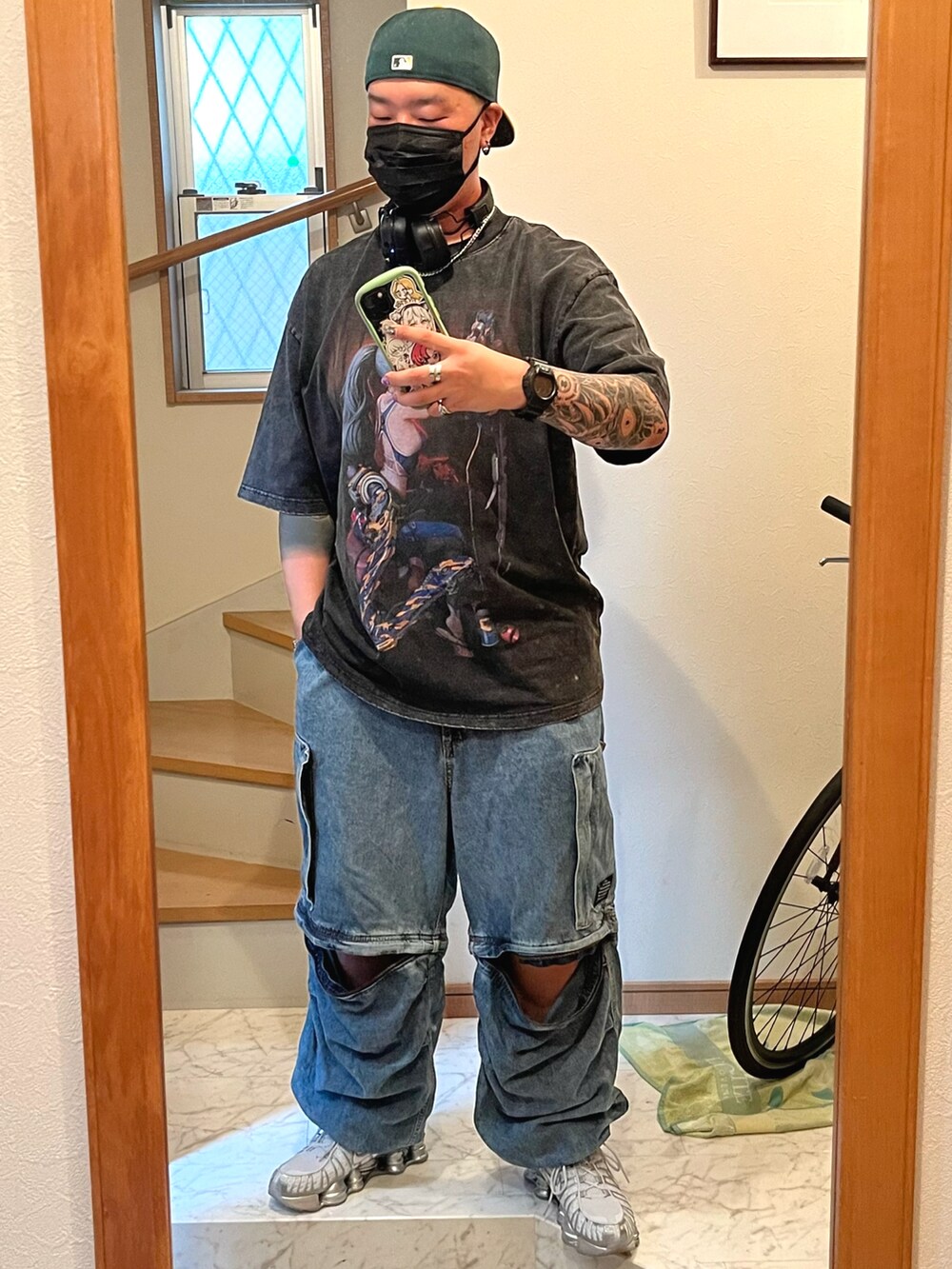 シルバー系のスニーカー、ブラック系のベスト、ブラック系のTシャツ/カットソーを着用したメンズの秋コーディネートの2枚目の写真