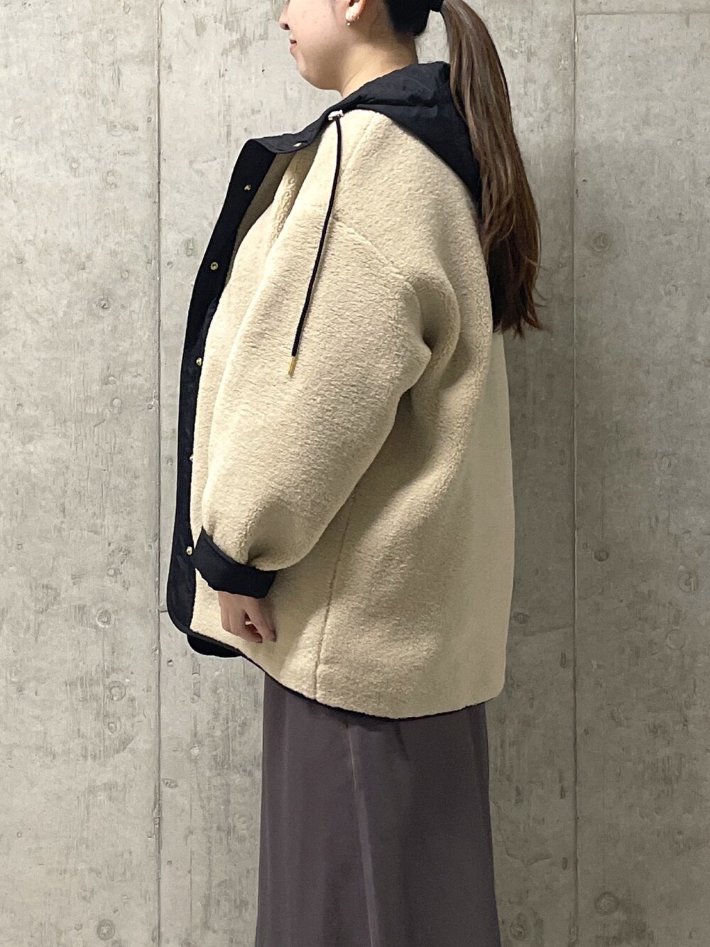 ブラウン系のスカート、ブラック系のボストンバッグ、ブラック系のブーツを着用したレディースの秋コーディネートの6枚目の写真