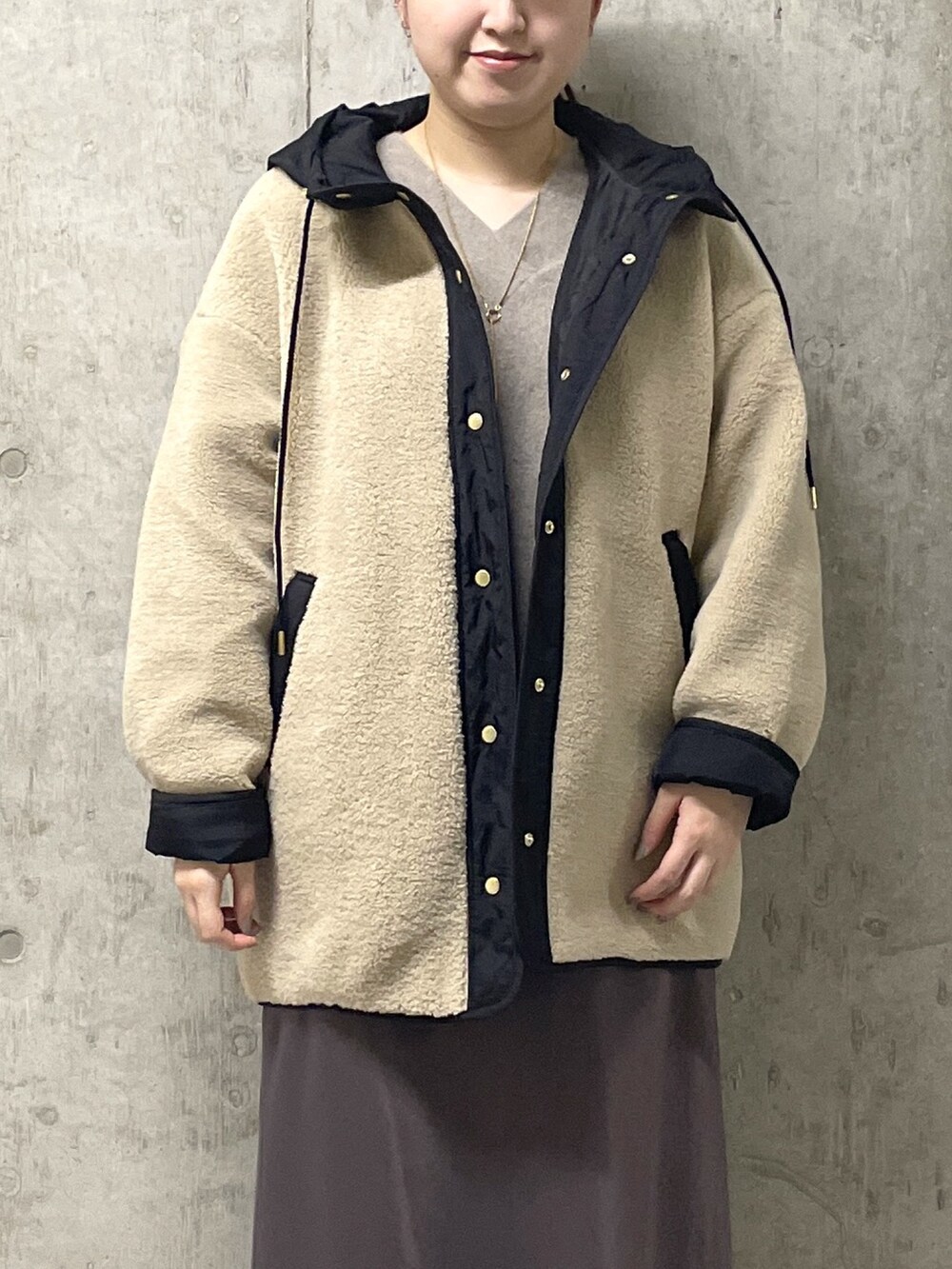 ブラウン系のスカート、ブラック系のボストンバッグ、ブラック系のブーツを着用したレディースの秋コーディネートの5枚目の写真