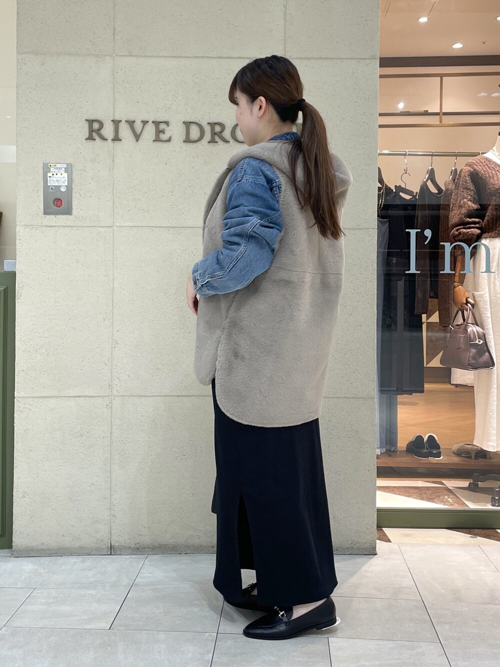 ブラック系のワンピース、ブラック系のローファー、ブラック系のショルダーバッグを着用したレディースの秋コーディネートの3枚目の写真