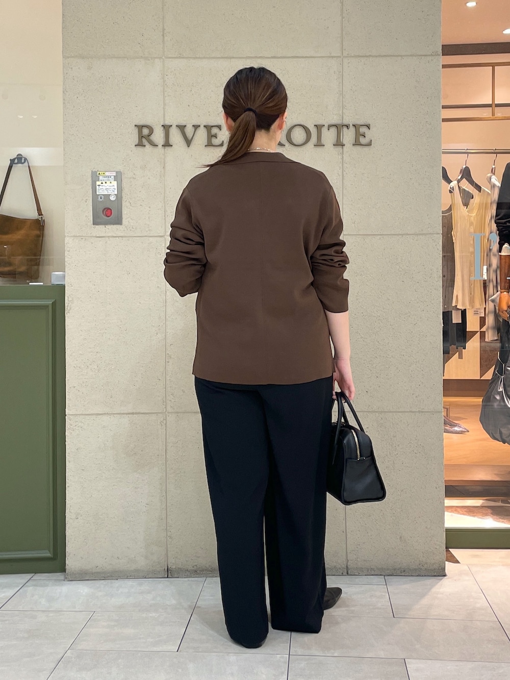 ブラック系のスラックス、ブラウン系のテーラードジャケット、ホワイト系のTシャツ/カットソーを着用したレディースの夏コーディネートの4枚目の写真