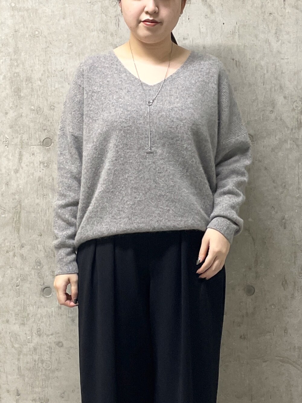 ブラック系のスラックス、グレー系のニット/セーター、ブラック系のローファーを着用したレディースの秋コーディネートの5枚目の写真