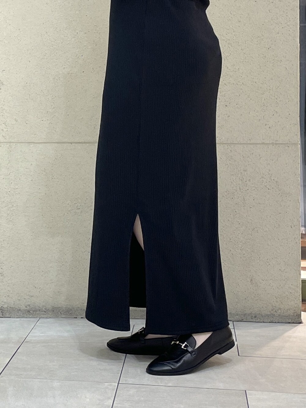 ブラック系のワンピース、ブラック系のローファー、ブラック系のショルダーバッグを着用したレディースの秋コーディネートの9枚目の写真