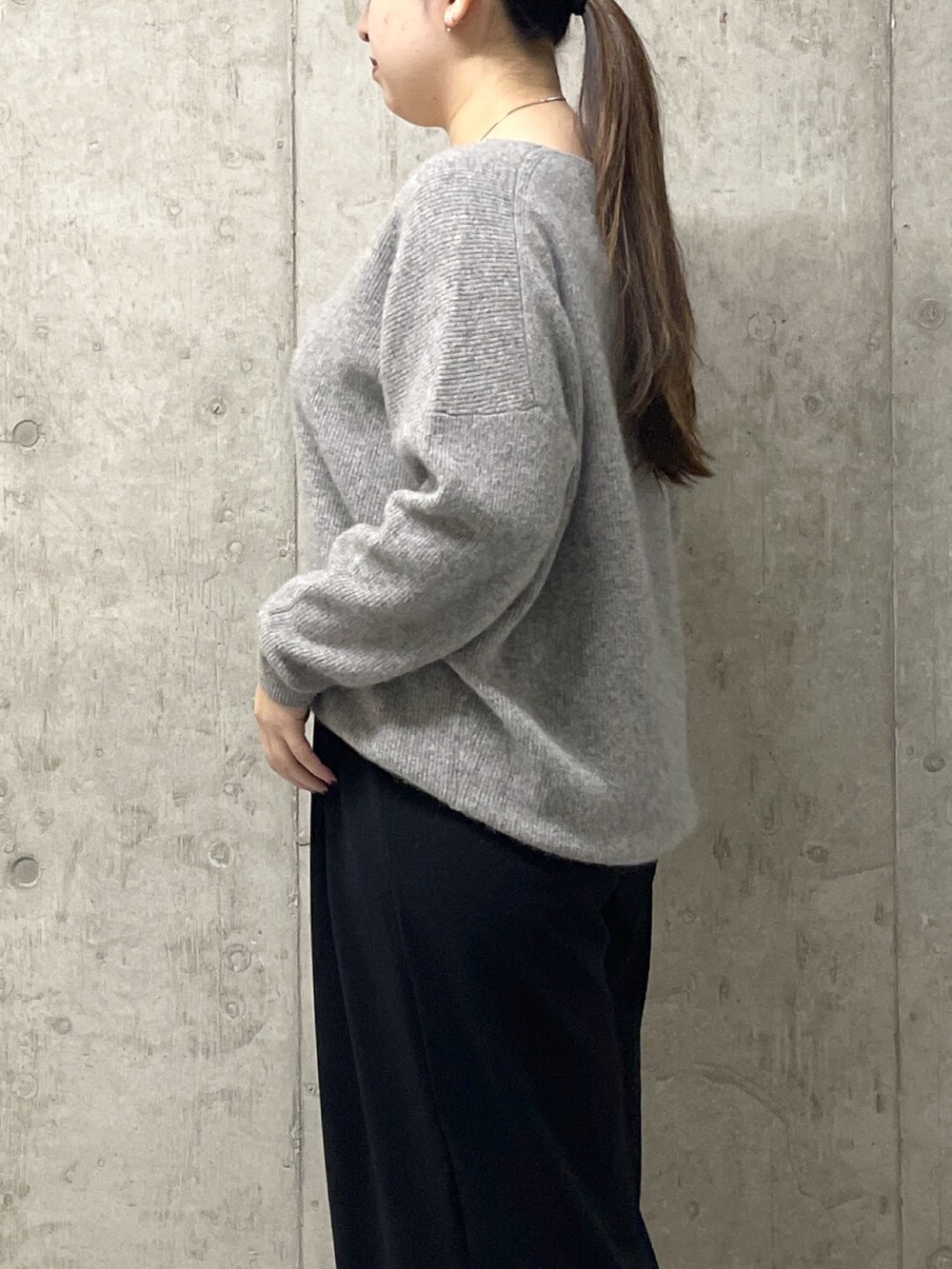 ブラック系のスラックス、グレー系のニット/セーター、ブラック系のローファーを着用したレディースの秋コーディネートの6枚目の写真