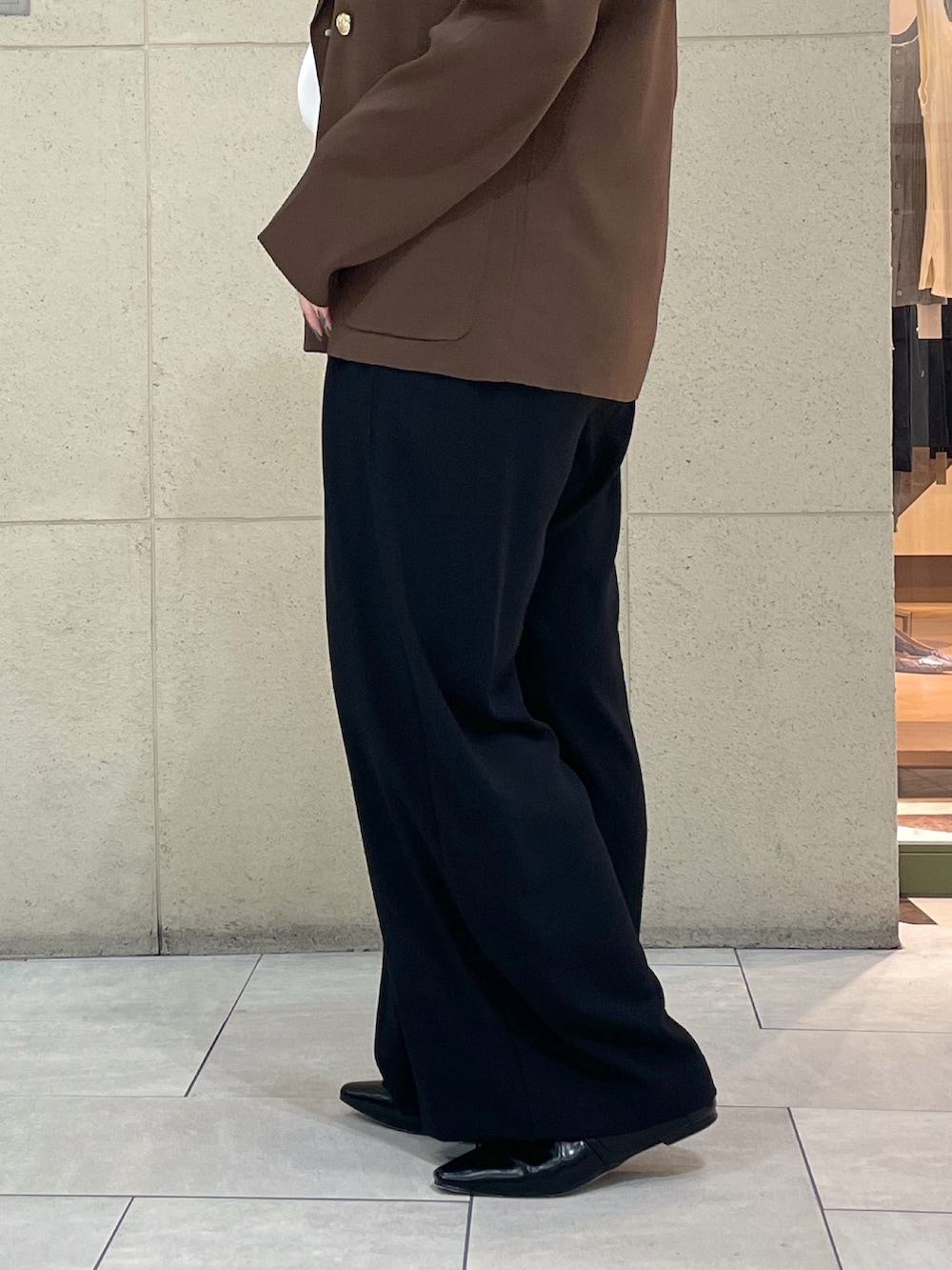 ブラック系のスラックス、ブラウン系のテーラードジャケット、ホワイト系のTシャツ/カットソーを着用したレディースの夏コーディネートの9枚目の写真