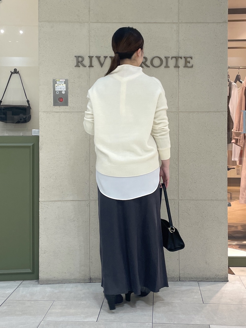 ホワイト系のニット/セーター、ホワイト系のシャツ/ブラウス、ブラック系のブーツを着用したレディースの冬コーディネートの4枚目の写真