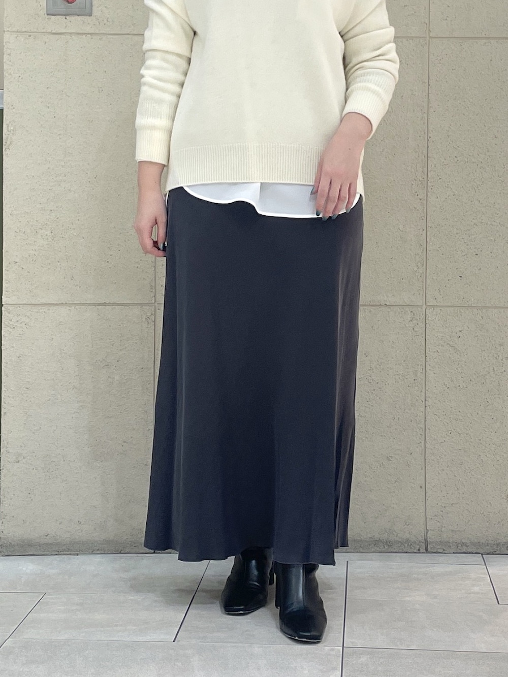 ホワイト系のニット/セーター、ホワイト系のシャツ/ブラウス、ブラック系のブーツを着用したレディースの冬コーディネートの8枚目の写真