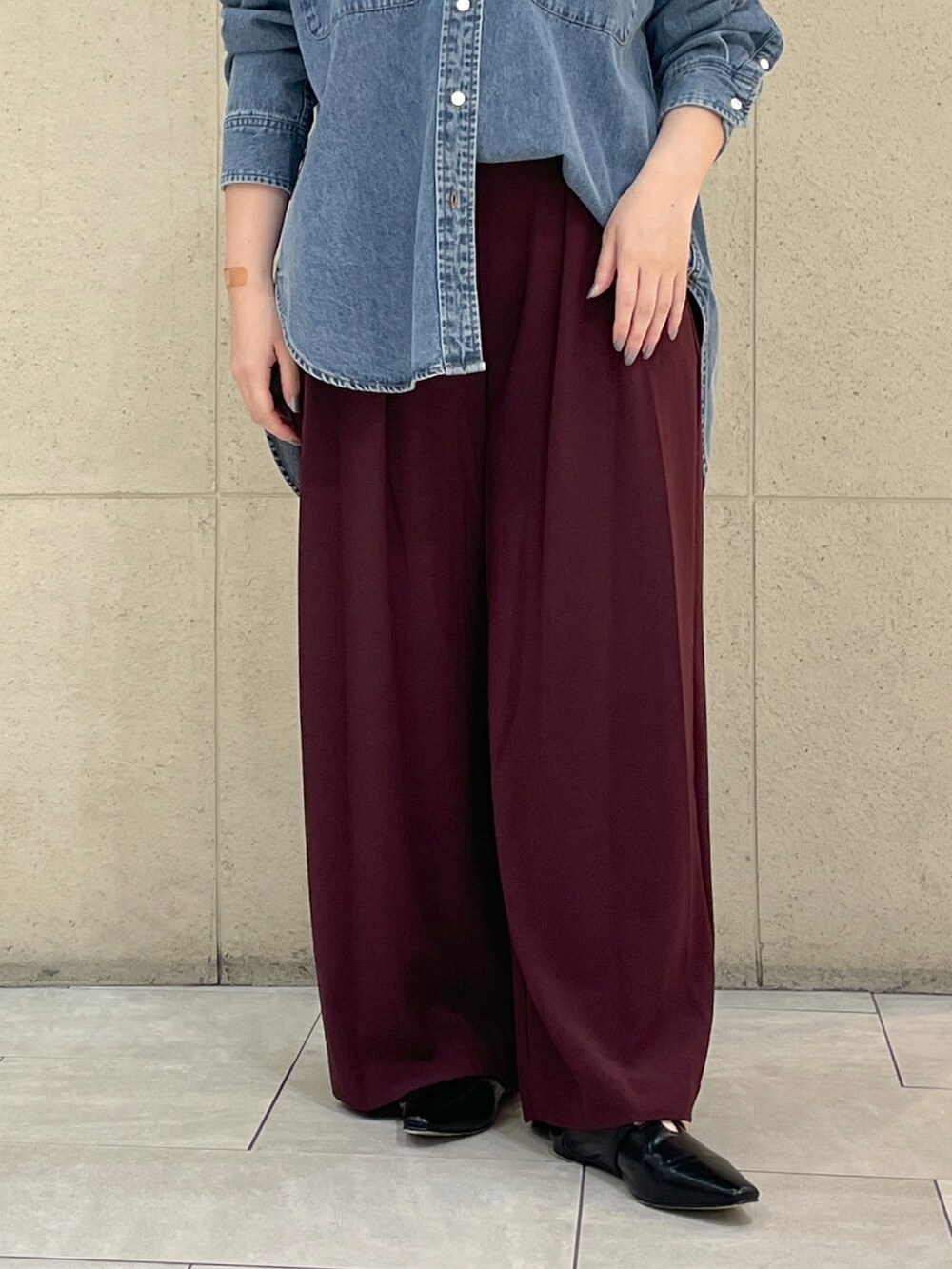 レッド系のスラックス、ブラック系のその他シューズ、ブラック系のボストンバッグを着用したレディースの秋コーディネートの8枚目の写真