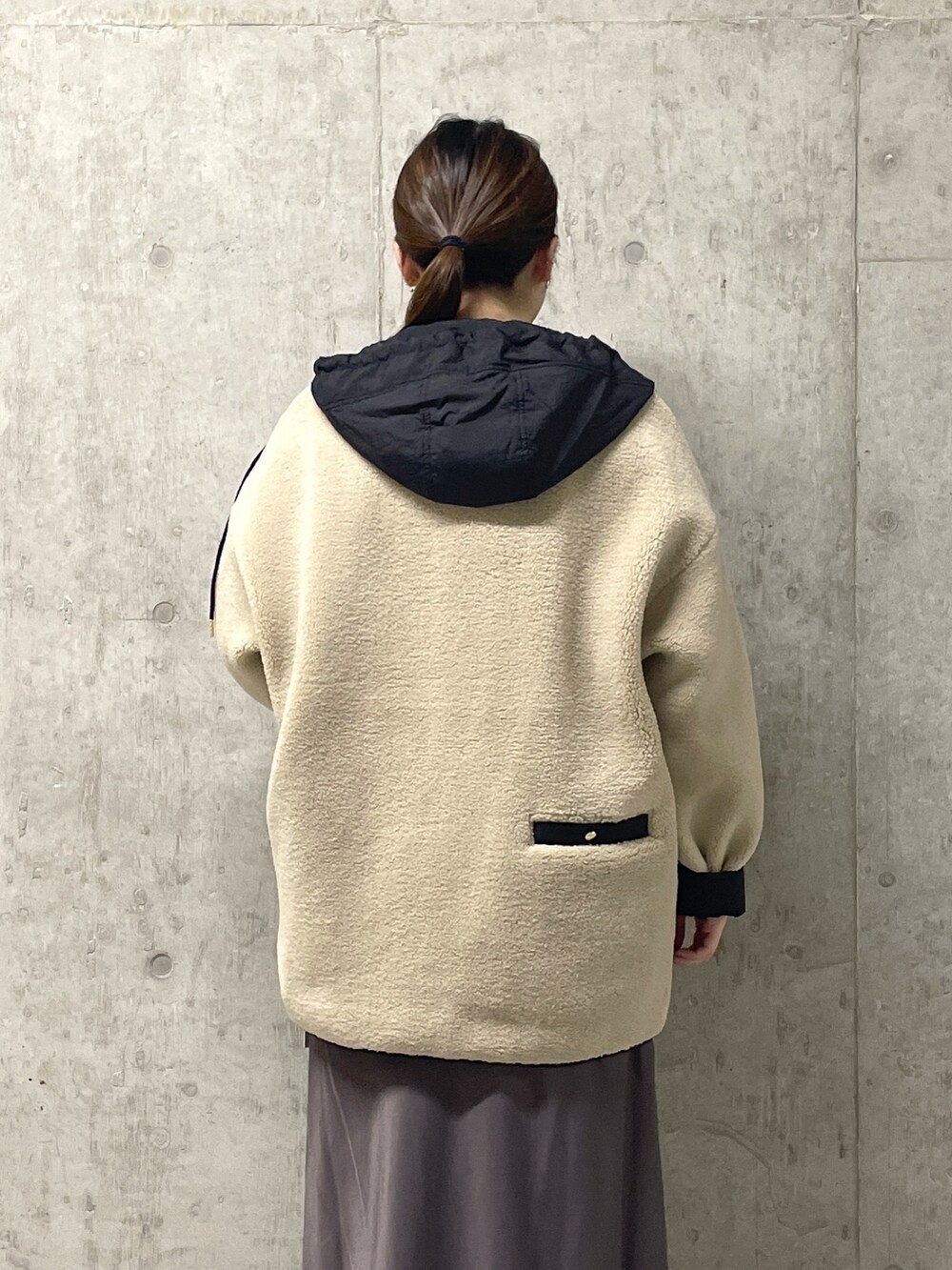 ブラウン系のスカート、ブラック系のボストンバッグ、ブラック系のブーツを着用したレディースの秋コーディネートの7枚目の写真