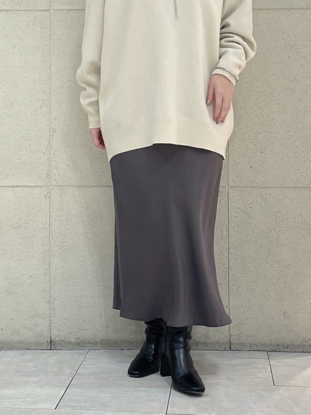 ホワイト系のニット/セーター、ホワイト系のTシャツ/カットソー、ブラウン系のスカートを着用したレディースの秋コーディネートの8枚目の写真