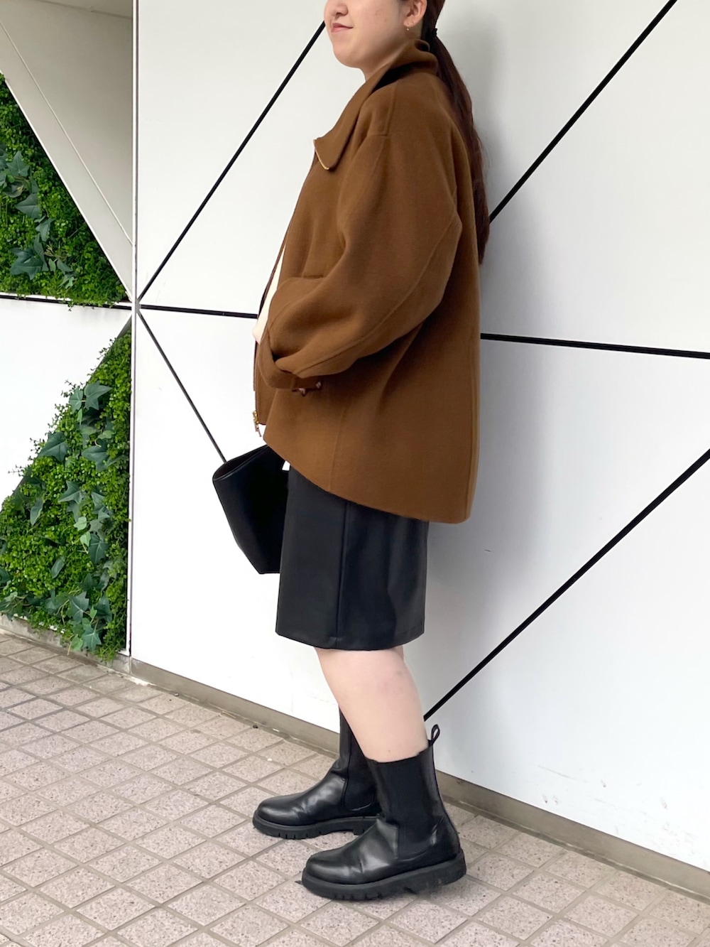 ブラック系のブーツ、ブラック系のその他パンツ、ブラック系のハンドバッグを着用したレディースの秋コーディネートの3枚目の写真