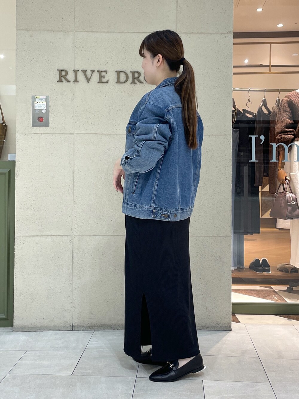 ブラック系のワンピース、ブラック系のローファー、ブラック系のショルダーバッグを着用したレディースの秋コーディネートの3枚目の写真