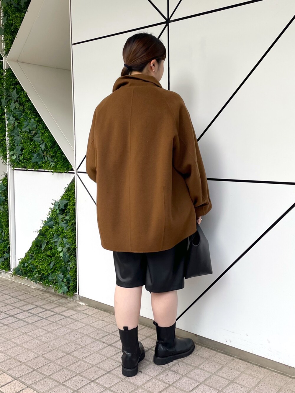 ブラック系のブーツ、ブラック系のその他パンツ、ブラック系のハンドバッグを着用したレディースの秋コーディネートの4枚目の写真