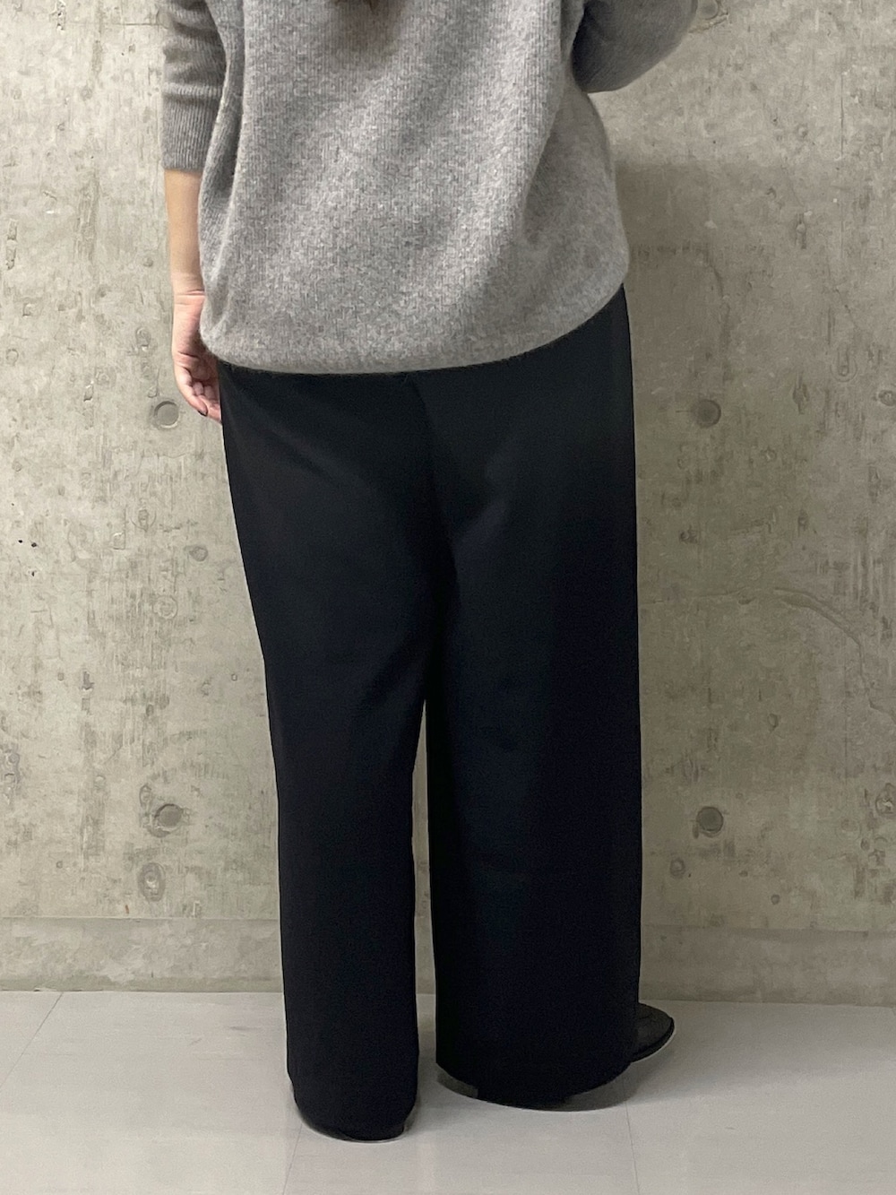 ブラック系のスラックス、グレー系のニット/セーター、ブラック系のローファーを着用したレディースの秋コーディネートの10枚目の写真