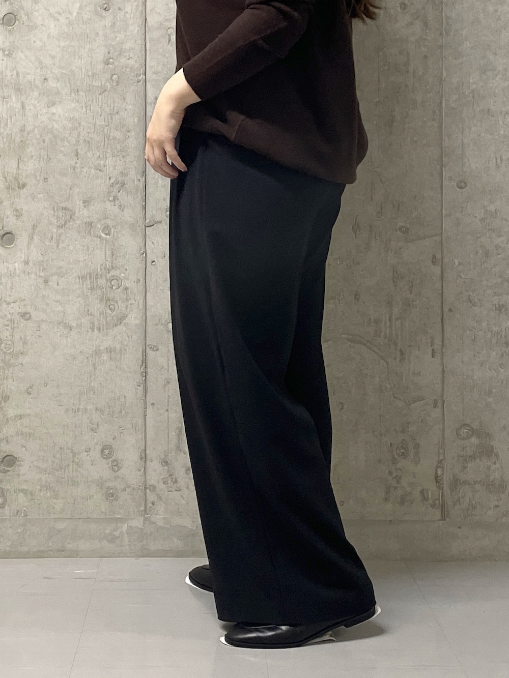 ブラウン系のニット/セーター、ブラック系のスラックス、イエロー系のハンドバッグを着用したレディースの秋コーディネートの9枚目の写真