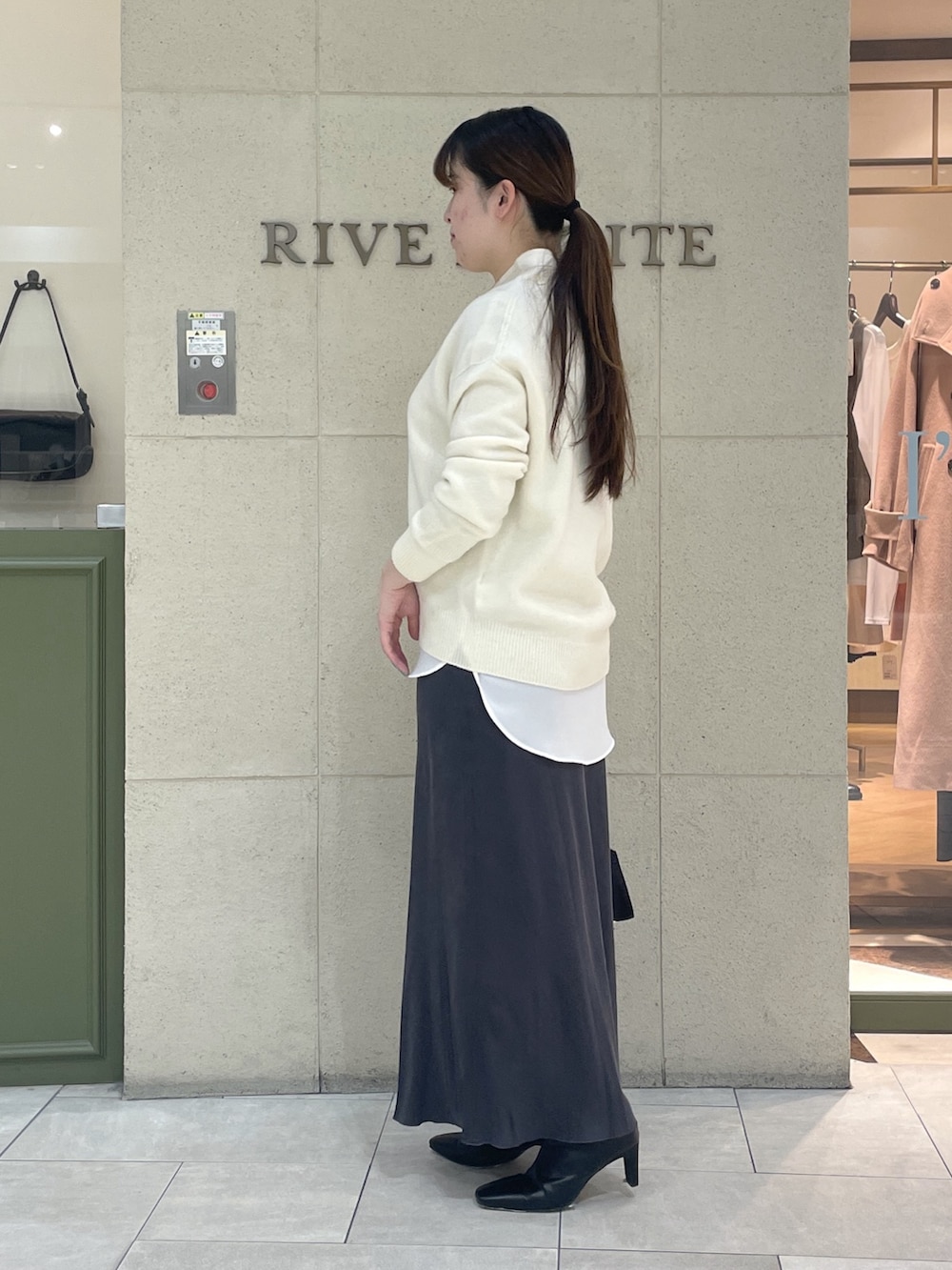 ホワイト系のニット/セーター、ホワイト系のシャツ/ブラウス、ブラック系のブーツを着用したレディースの冬コーディネートの3枚目の写真