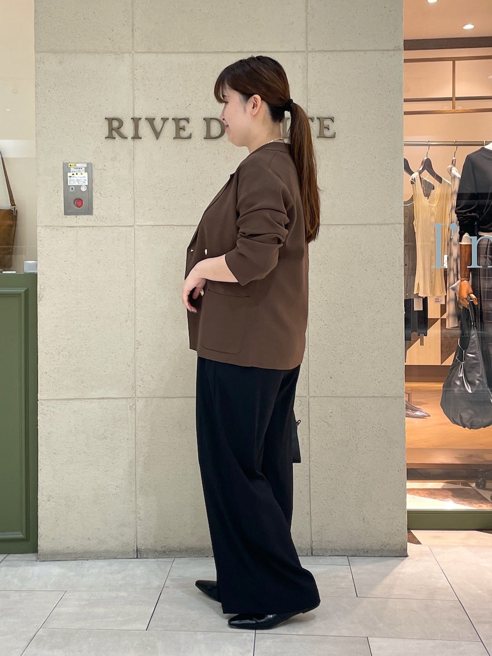 ブラック系のスラックス、ブラウン系のテーラードジャケット、ホワイト系のTシャツ/カットソーを着用したレディースの夏コーディネートの3枚目の写真