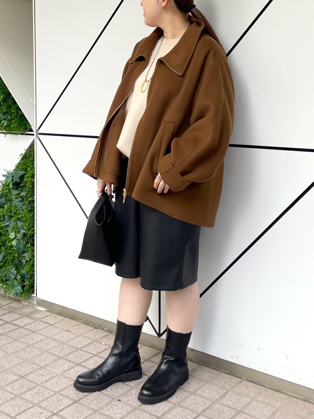 ブラック系のブーツ、ブラック系のその他パンツ、ブラック系のハンドバッグを着用したレディースの秋コーディネートの2枚目の写真