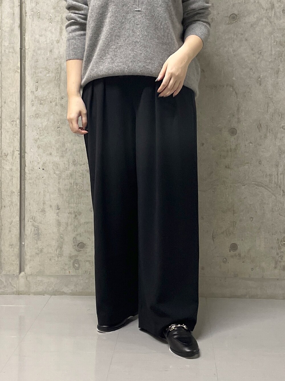 ブラック系のスラックス、グレー系のニット/セーター、ブラック系のローファーを着用したレディースの秋コーディネートの8枚目の写真