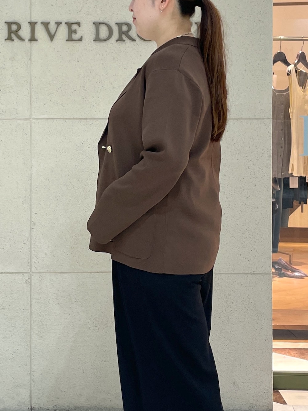 ブラック系のスラックス、ブラウン系のテーラードジャケット、ホワイト系のTシャツ/カットソーを着用したレディースの夏コーディネートの6枚目の写真