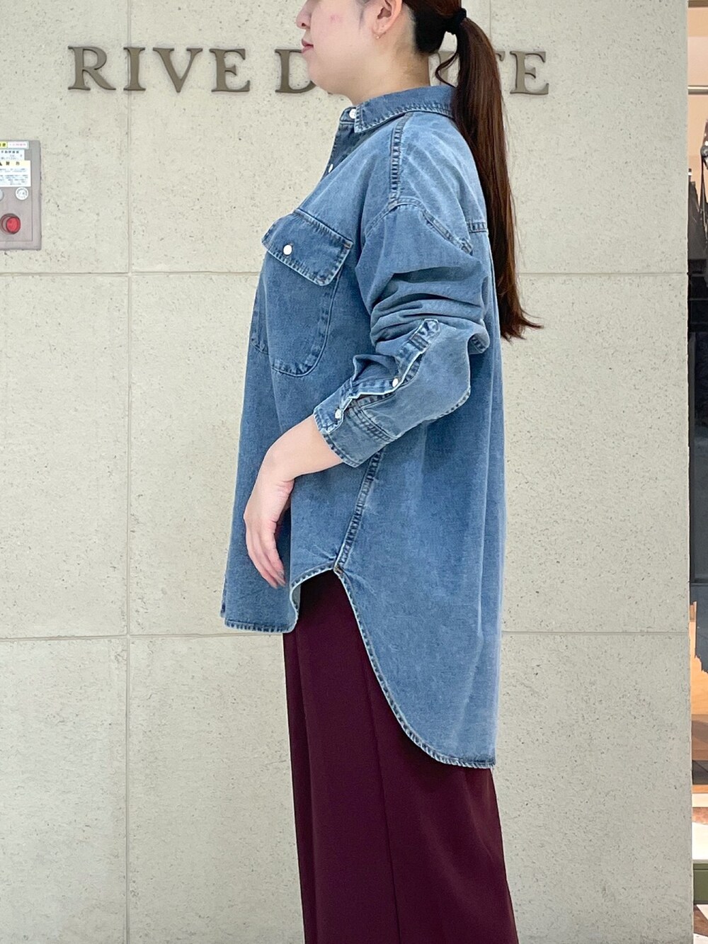 レッド系のスラックス、ブラック系のその他シューズ、ブラック系のボストンバッグを着用したレディースの秋コーディネートの6枚目の写真