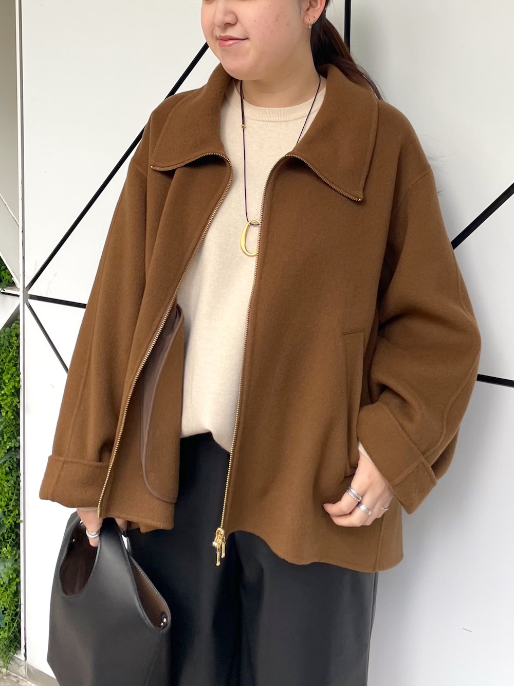 ブラック系のブーツ、ブラック系のその他パンツ、ブラック系のハンドバッグを着用したレディースの秋コーディネートの5枚目の写真