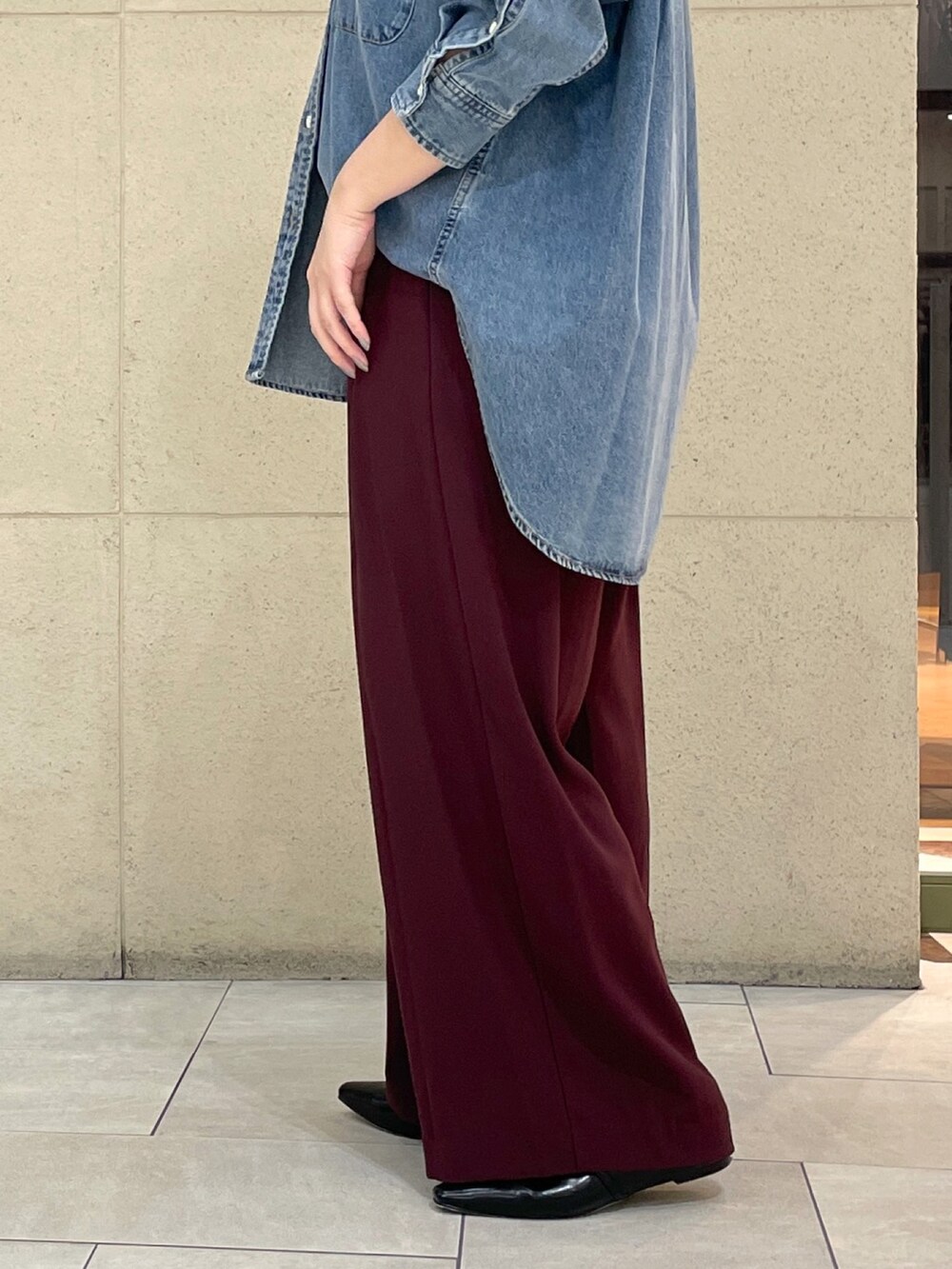 レッド系のスラックス、ブラック系のその他シューズ、ブラック系のボストンバッグを着用したレディースの秋コーディネートの9枚目の写真