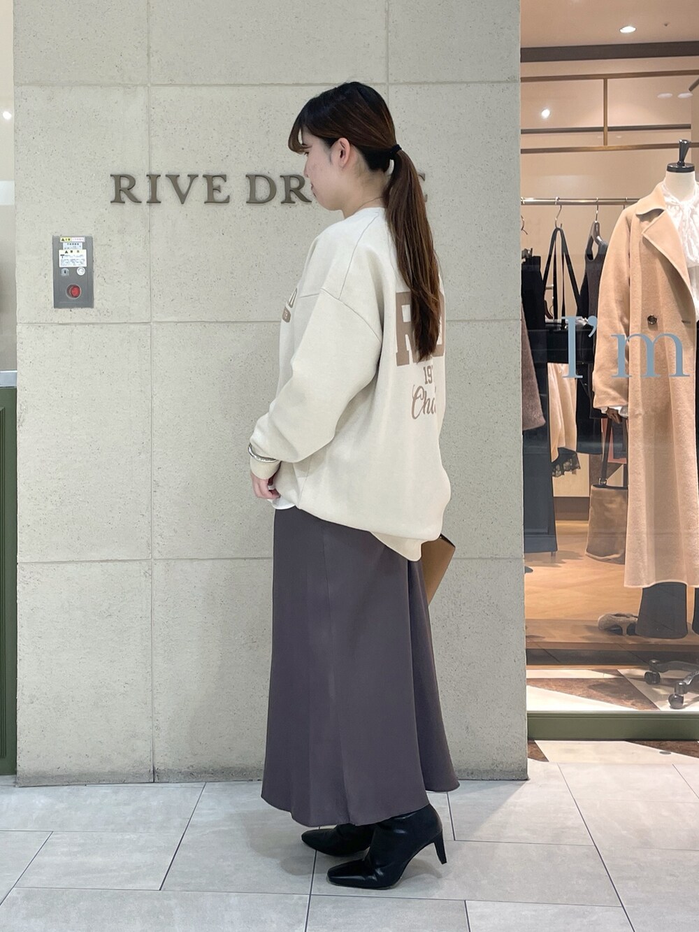 ホワイト系のニット/セーター、ホワイト系のTシャツ/カットソー、ブラウン系のスカートを着用したレディースの秋コーディネートの3枚目の写真