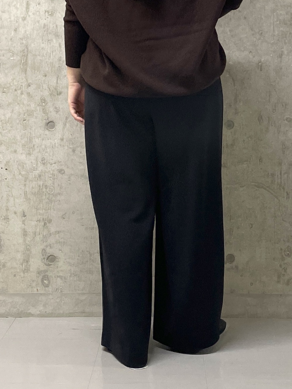 ブラウン系のニット/セーター、ブラック系のスラックス、イエロー系のハンドバッグを着用したレディースの秋コーディネートの10枚目の写真