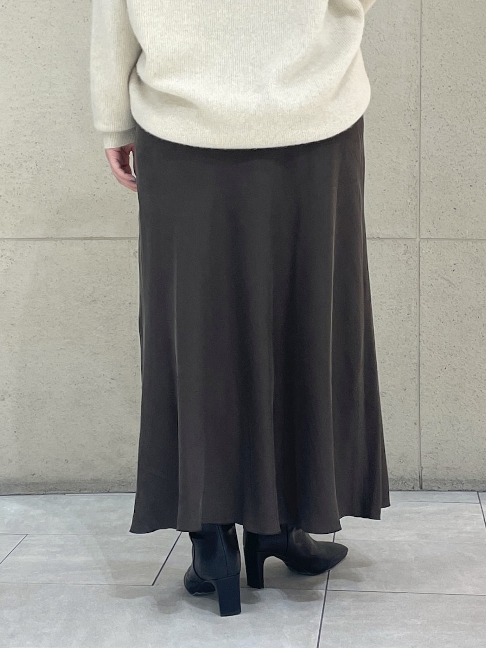 ベージュ系のニット/セーター、ブラウン系のスカート、ブラック系のボストンバッグを着用したレディースの秋コーディネートの10枚目の写真