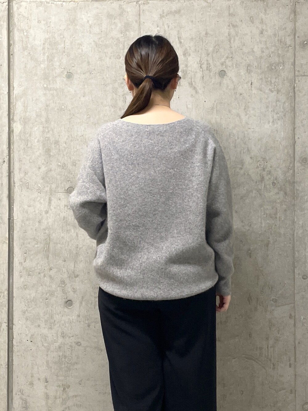 ブラック系のスラックス、グレー系のニット/セーター、ブラック系のローファーを着用したレディースの秋コーディネートの7枚目の写真