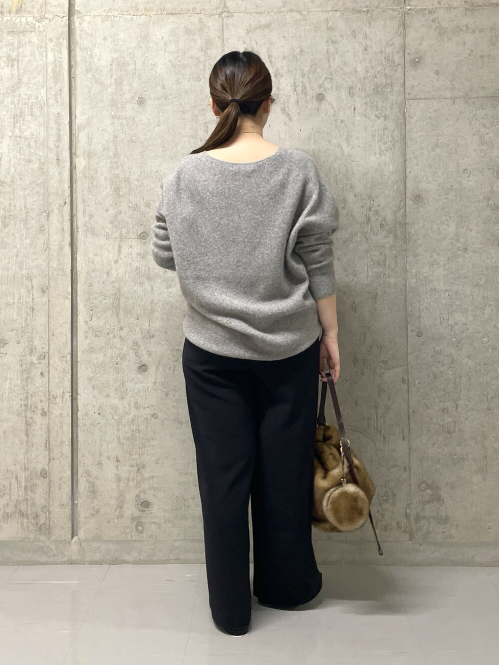 ブラック系のスラックス、グレー系のニット/セーター、ブラック系のローファーを着用したレディースの秋コーディネートの4枚目の写真