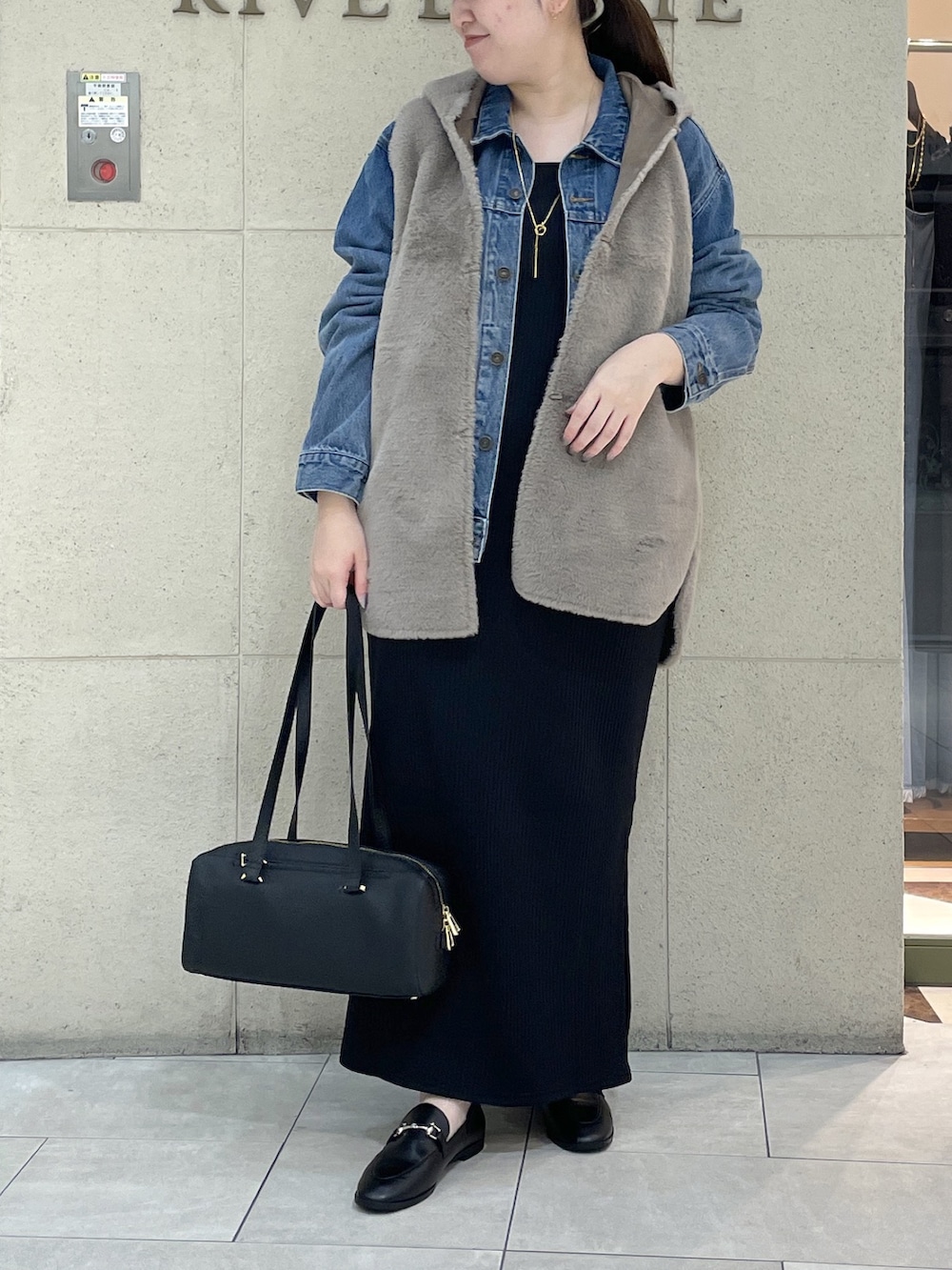 ブラック系のワンピース、ブラック系のローファー、ブラック系のショルダーバッグを着用したレディースの秋コーディネートの2枚目の写真