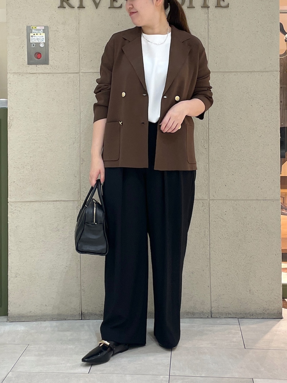 ブラック系のスラックス、ブラウン系のテーラードジャケット、ホワイト系のTシャツ/カットソーを着用したレディースの夏コーディネートの2枚目の写真