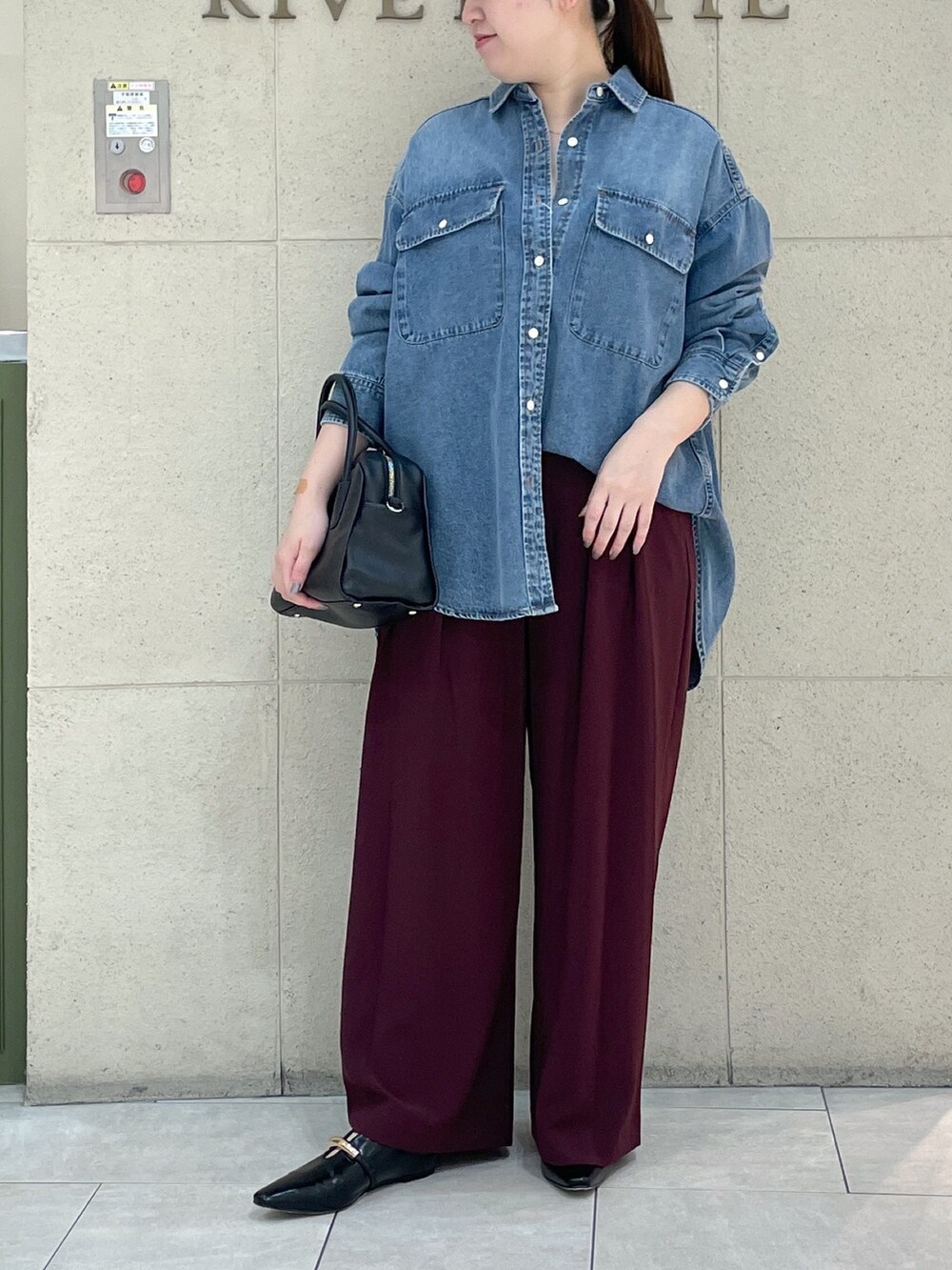 レッド系のスラックス、ブラック系のその他シューズ、ブラック系のボストンバッグを着用したレディースの秋コーディネートの2枚目の写真