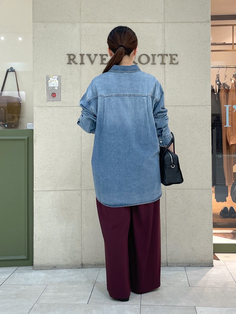 レッド系のスラックス、ブラック系のその他シューズ、ブラック系のボストンバッグを着用したレディースの秋コーディネートの4枚目の写真