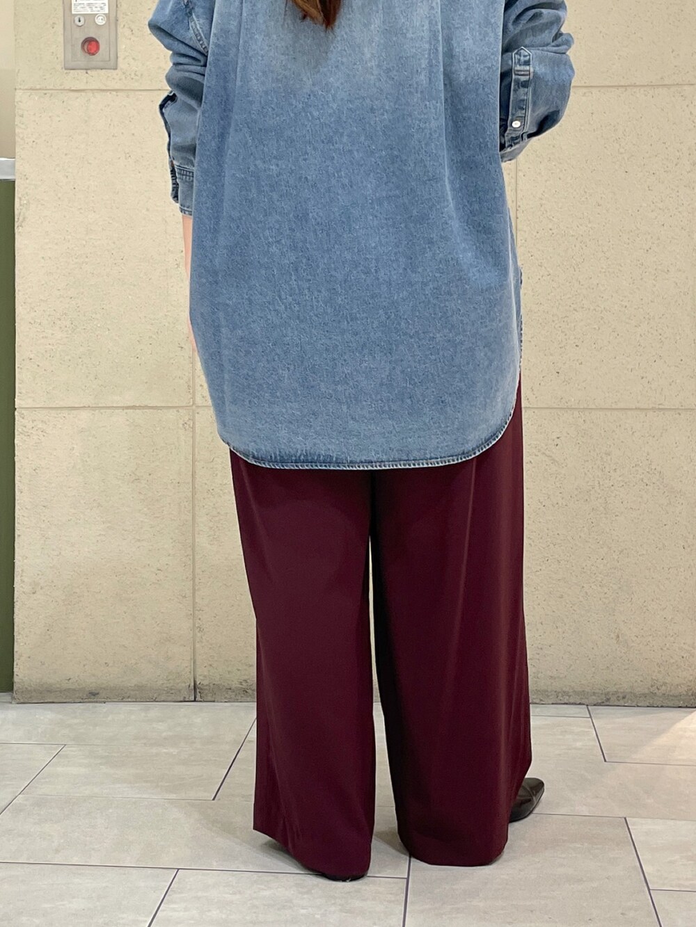 レッド系のスラックス、ブラック系のその他シューズ、ブラック系のボストンバッグを着用したレディースの秋コーディネートの10枚目の写真